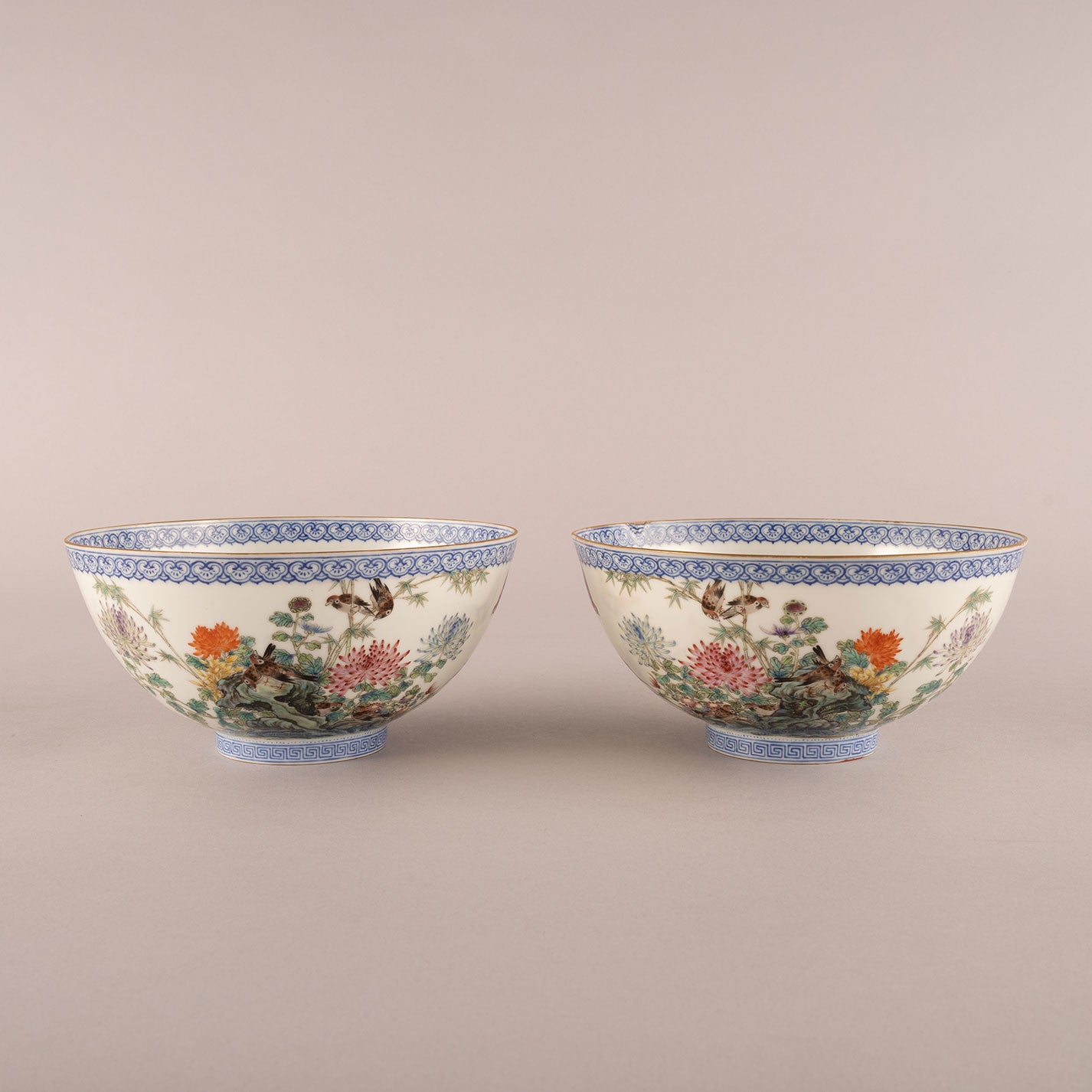 A pair of light-colored flower and bird bowls
