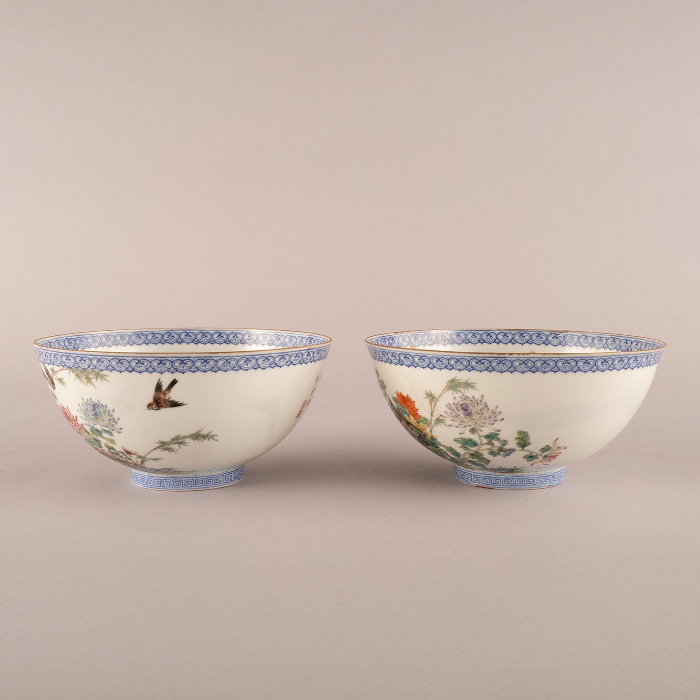 A pair of light-colored flower and bird bowls
