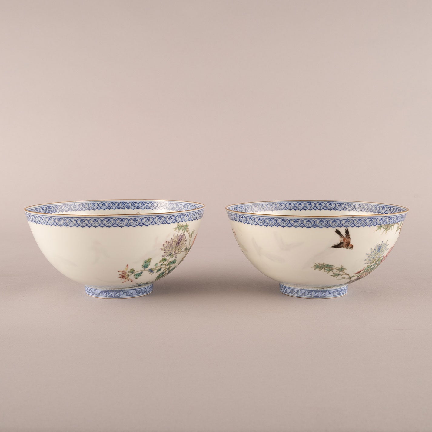 A pair of light-colored flower and bird bowls