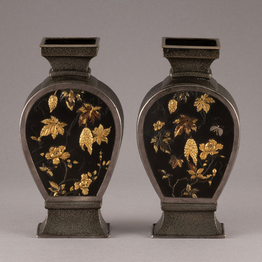 A pair of copper vases with insect and flower designs