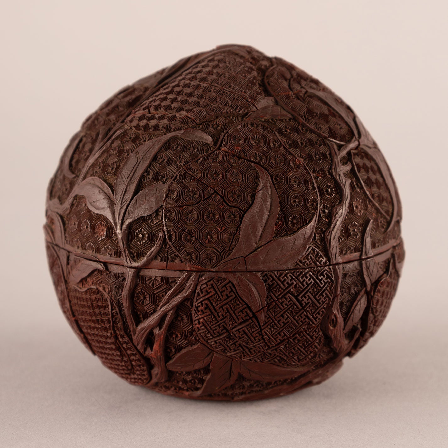 Carved red peach-shaped box with lid